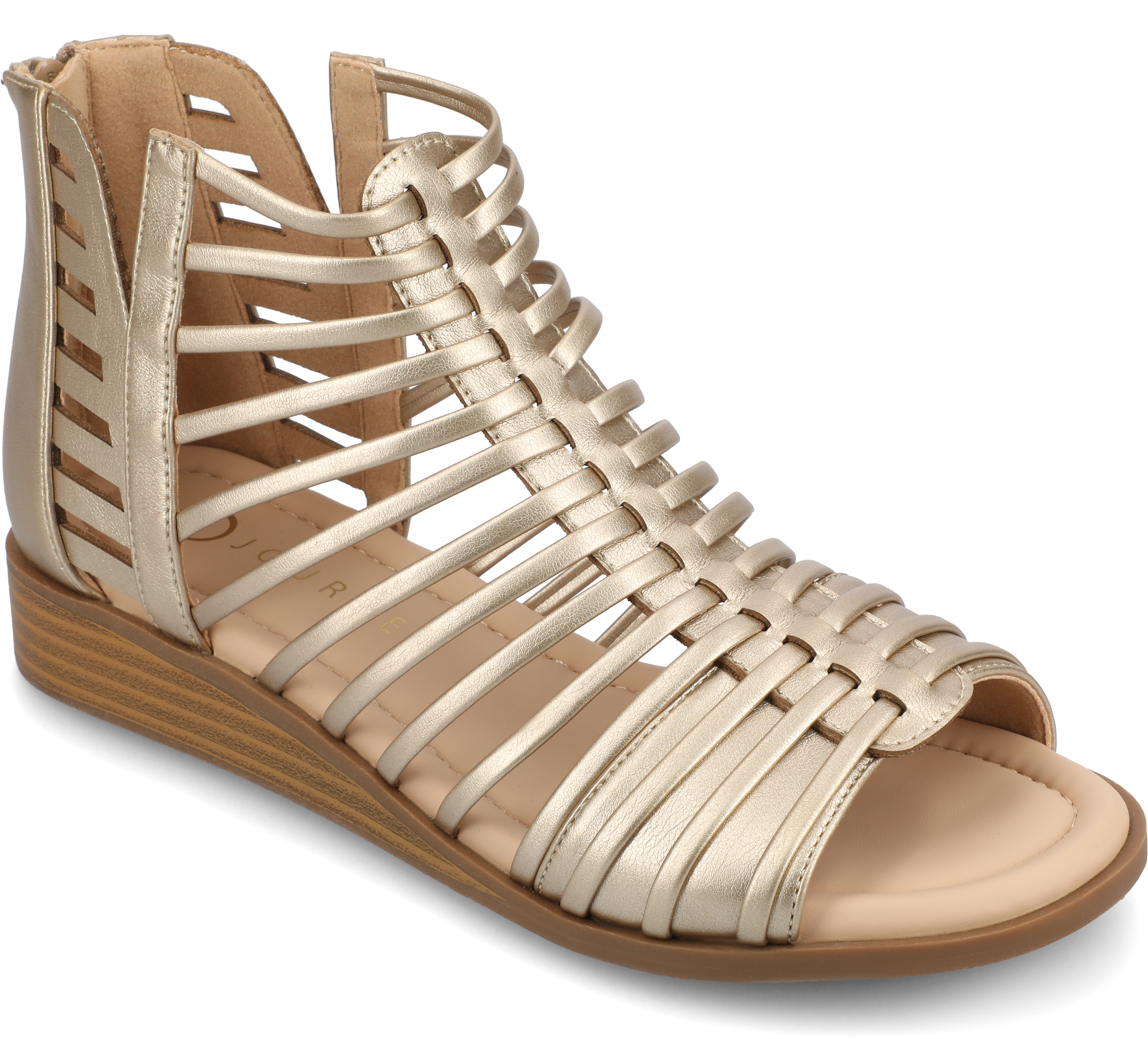 Close-up of feet wearing tan, strappy gladiator-style sandals on a textured beige blanket.
