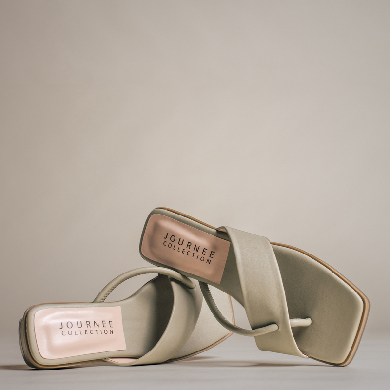 Close-up image of a pair of beige square-toe sandals with a minimalist strap design, positioned in a stylish, overlapping arrangement on a neutral background.