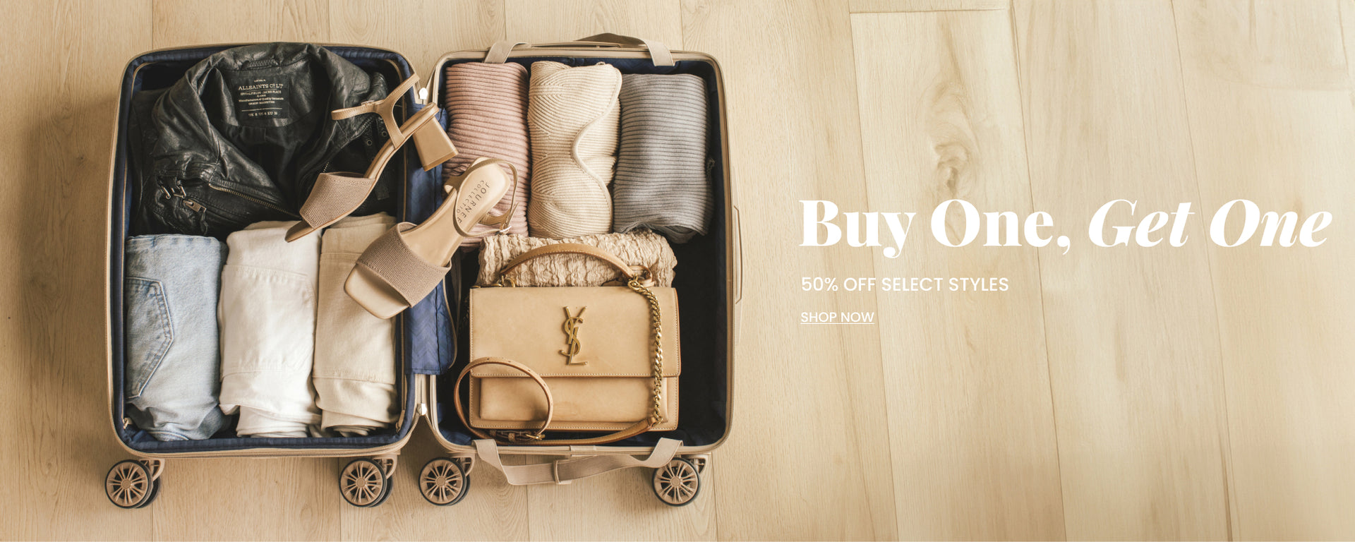 Hero image: open suit case with luxury clothes carefully folded inside. Nude colored Journee strappy sandals rest on top. Header text: "Buy One Get One 50% off select styles" CTA: "shop now" links to collection.