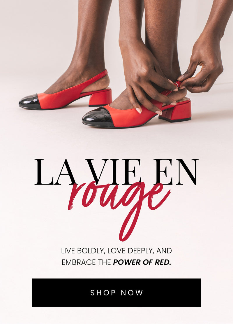 Close-up of a person adjusting the strap on red slingback heels with black patent leather toe caps and chunky heels, set against a minimalist off-white background. Text overlay reads 'La Vie En Rouge: Live boldly, love deeply, and embrace the power of red.' A black 'Shop Now' button is included.