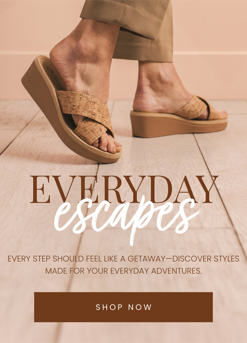 "Close-up of a person wearing cork-textured wedge sandals with crisscross straps, walking on a light wood floor. The text overlay reads 'Everyday Escapes' with a call-to-action button that says 'Shop Now.'"